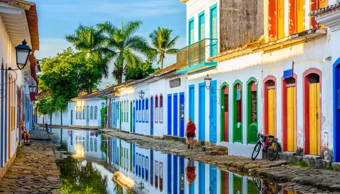 Rua do centro histórico alagada pela maré, refletindo os casarões