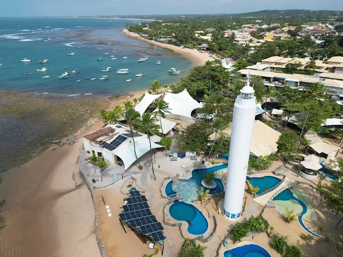 Vista aérea da base de Praia do Forte, com o farol e os tanques à beira-mar